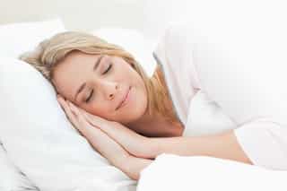 Person peacefully sleeping in a cozy bed.